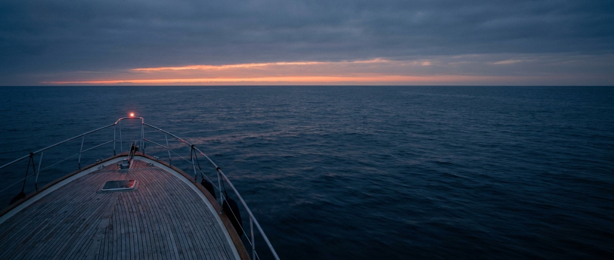 Open ocean at dusk seen from the deck of a motor yacht